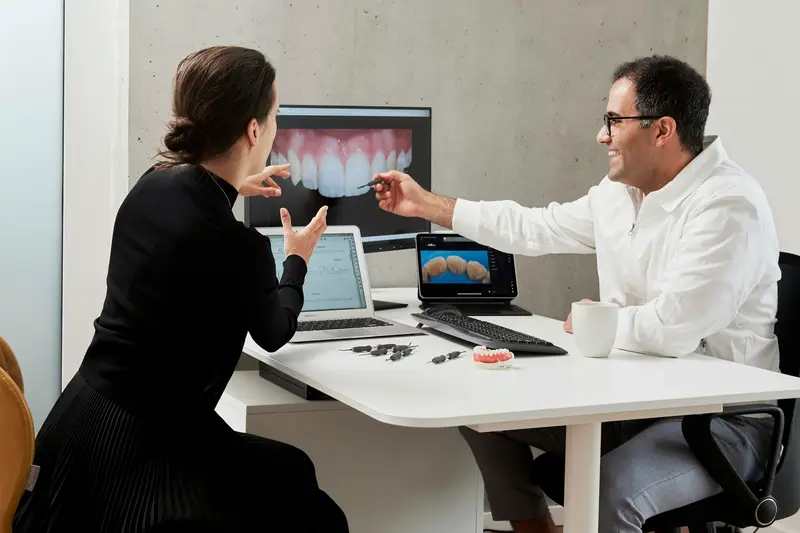 Dentist reviewing a smile design on screen with a patient