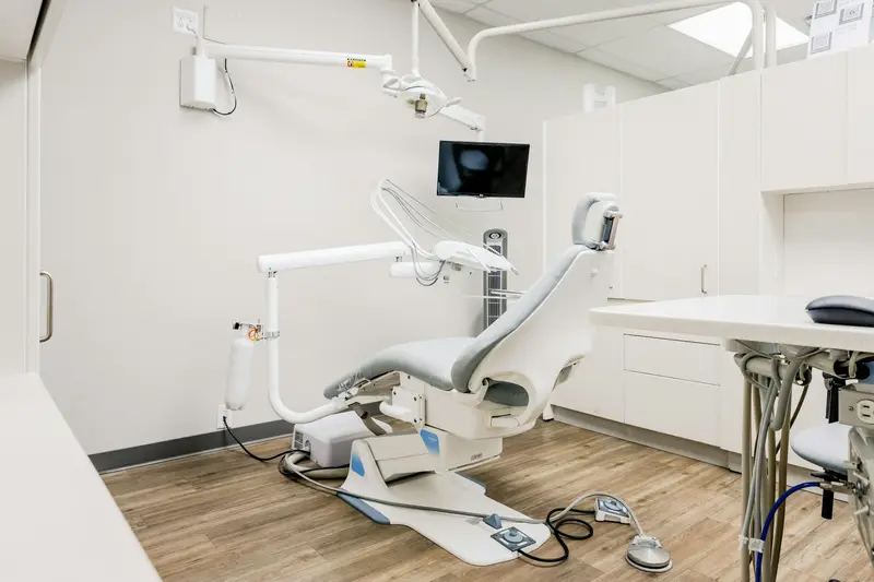 Modern treatment room with a dental chair and digital display
