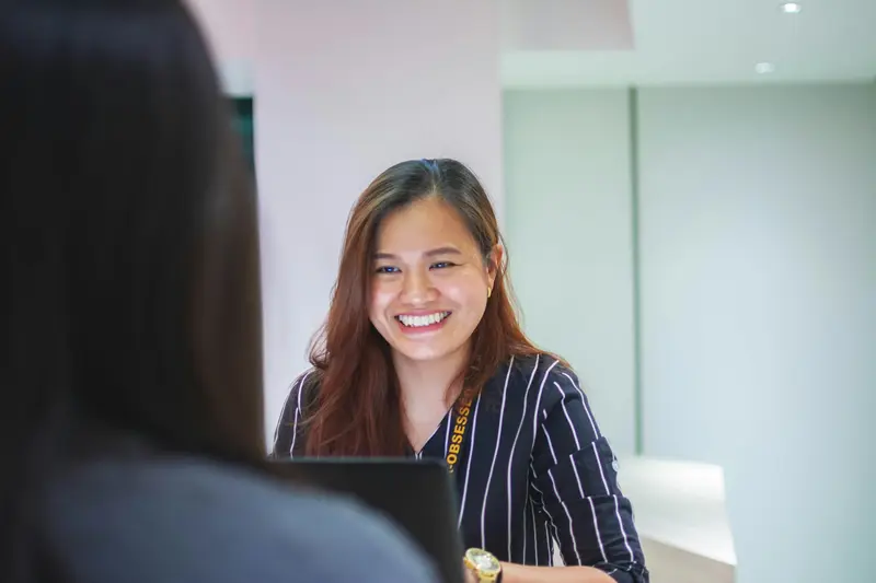Front desk coordinator greeting a patient at check-in