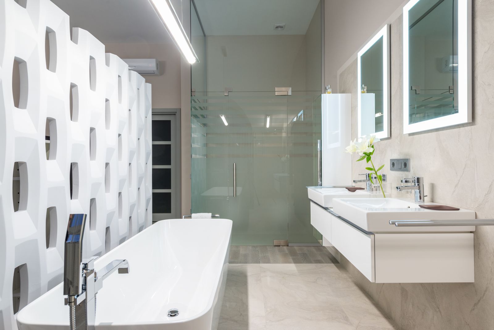 Freestanding tub by a glass shower