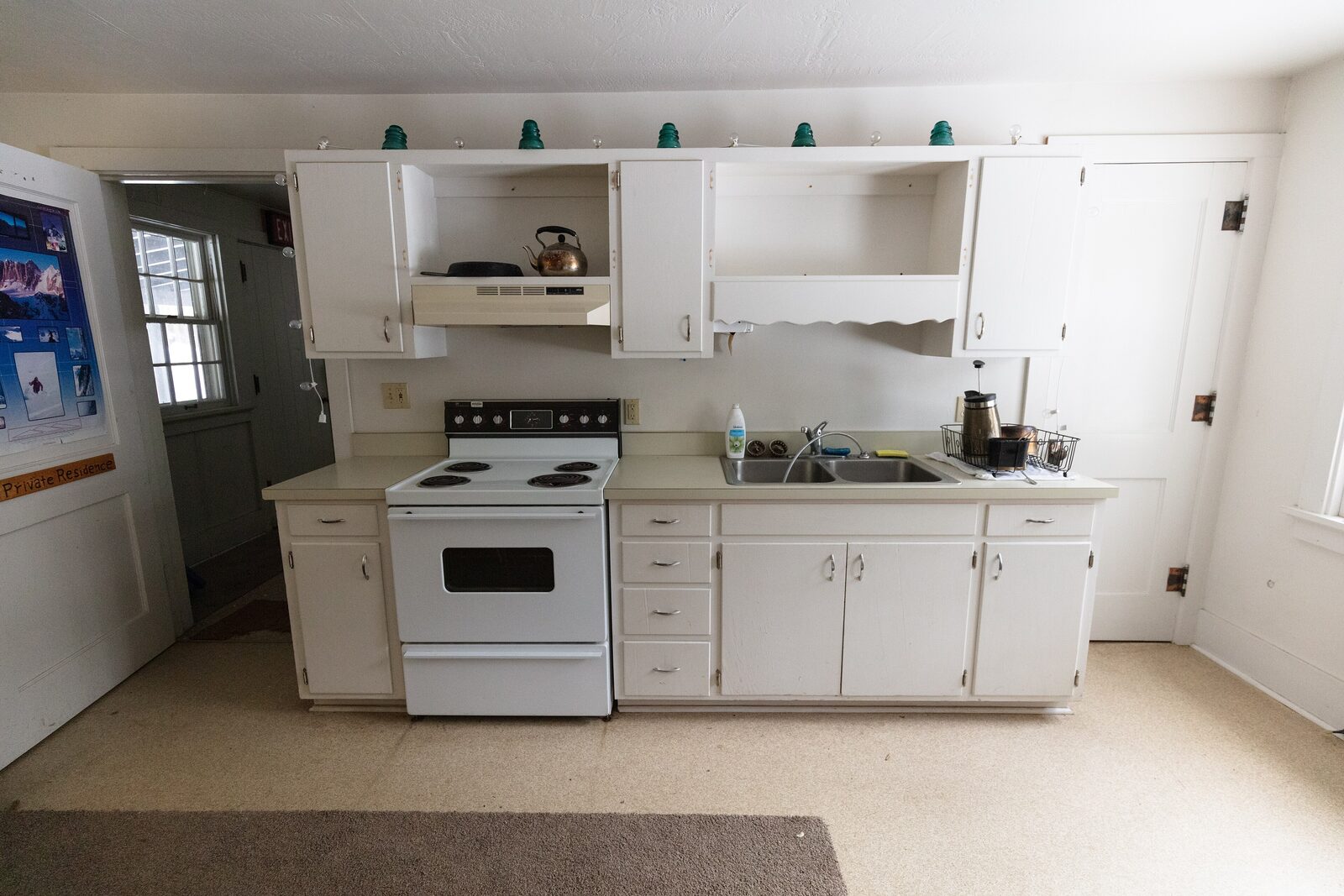 The original range wall with open shelves and a coil-top stove