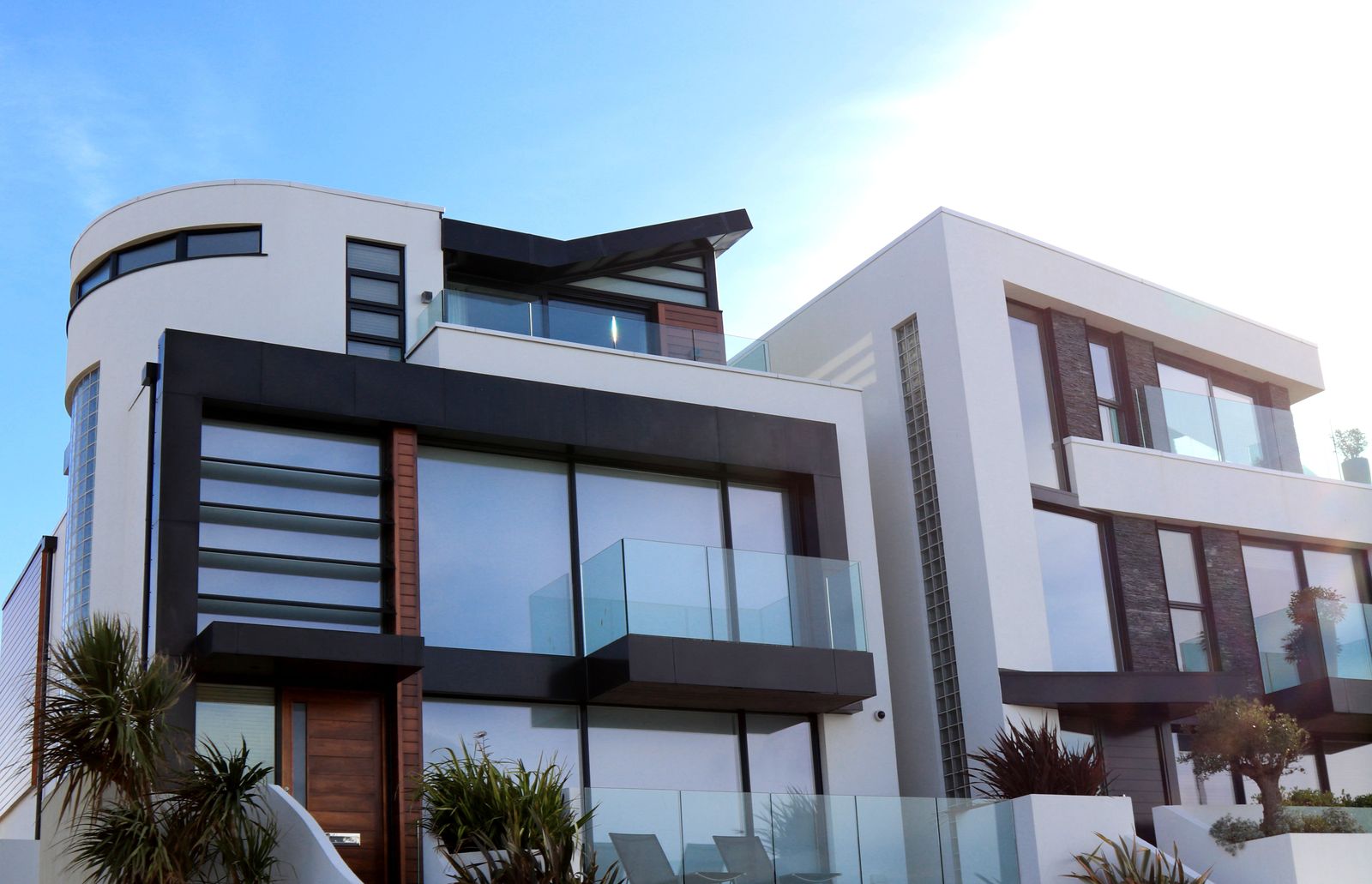 Modern custom home exterior with glass balconies and wood accents