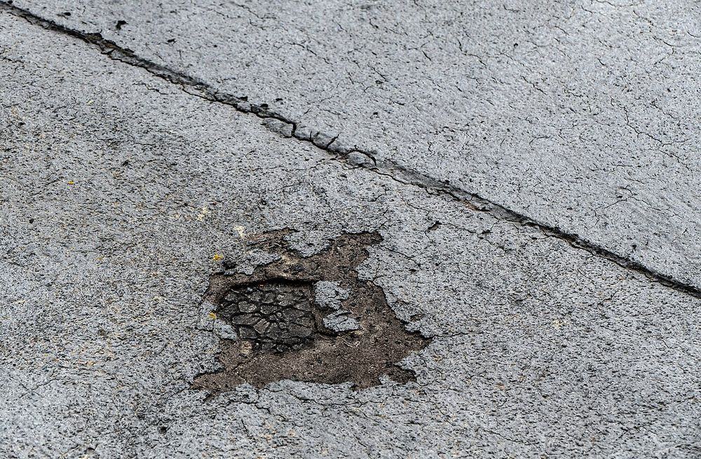 Cracked flat roof membrane with a hole worn through