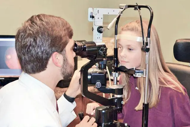 Optometrist examining a patient at a slit lamp